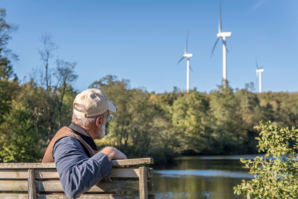 illustratieve foto bijna-met-pensioen-man-kijkt-windmolens