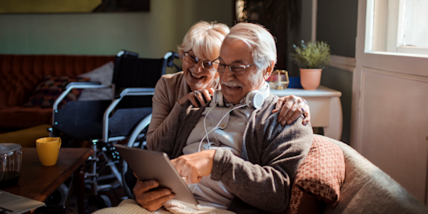 illustratie lachende oudere man en vrouw thuis met tablet